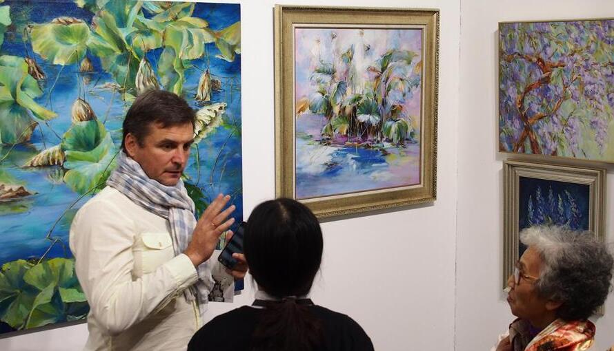 加拿大画商在上海艺术博览会介绍油画作品  新华社.jpg